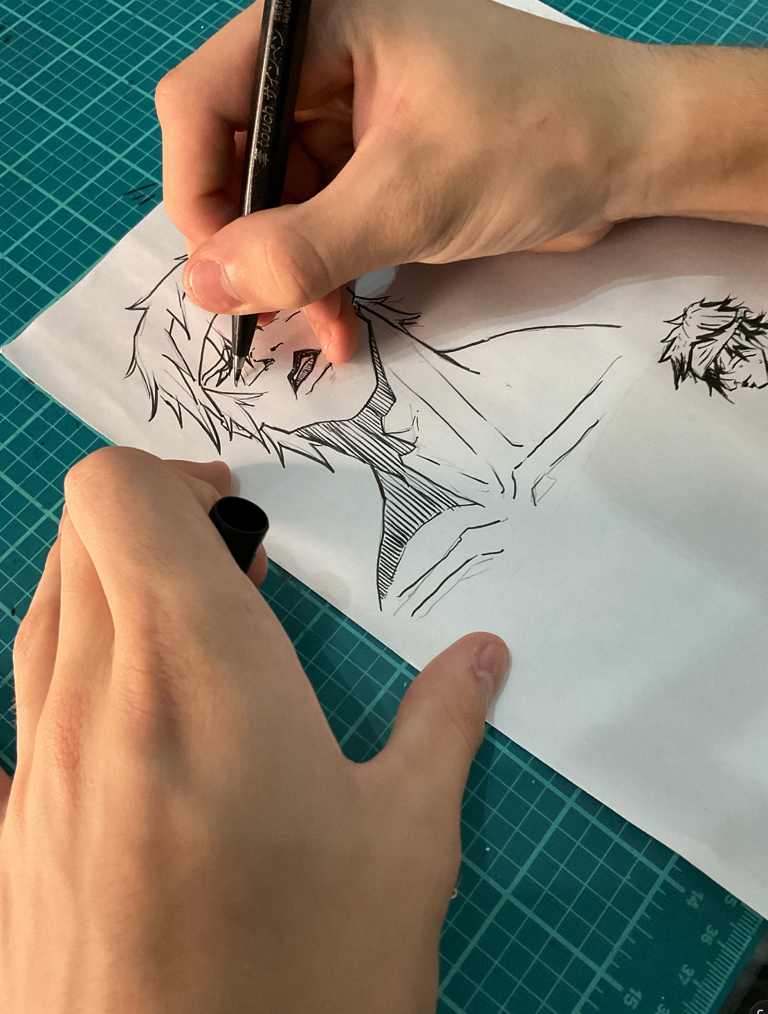 Primer plano de entintado manual de un personaje con plumilla sobre papel